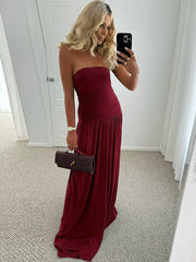 Woman in a burgundy strapless gown taking a mirror selfie.