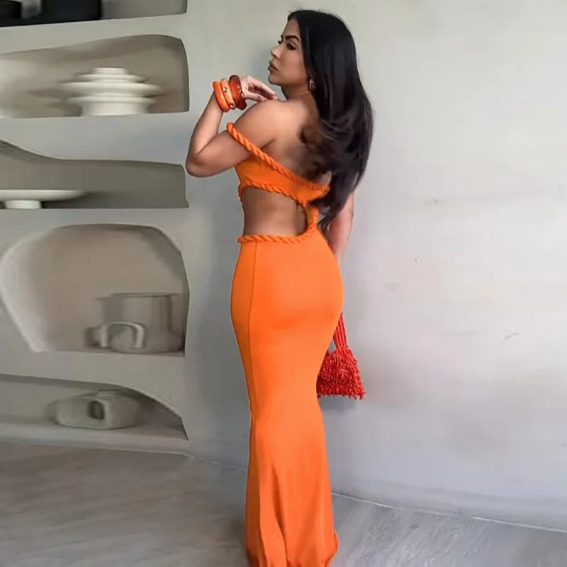 Woman in an orange dress standing in a modern interior setting