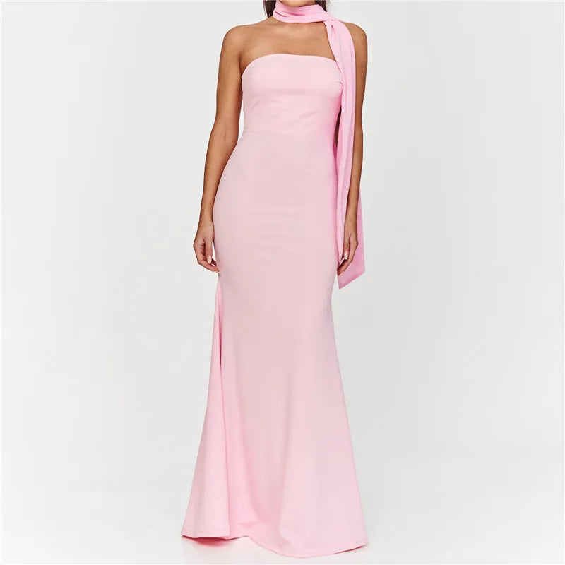 Pink halter neck gown with a draped fabric detail on a white background