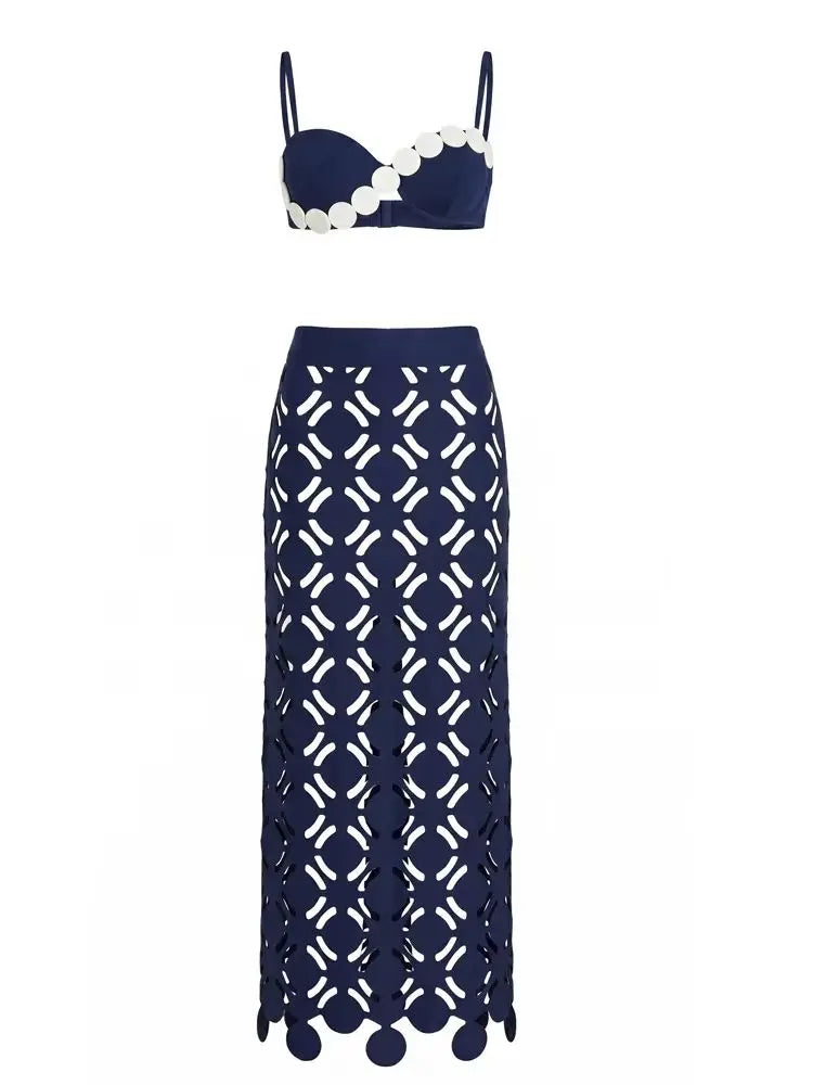 Product flat lay of a blue bikini top with white scalloped trim and a matching blue maxi skirt with geometric cut-outs.