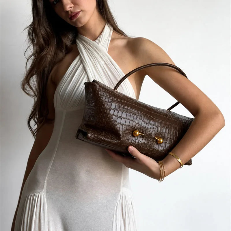 Crocodile embossed leather shoulder bag worn by a model