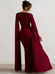 Model wearing a flowing cape sleeve maxi dress with a high split. 4