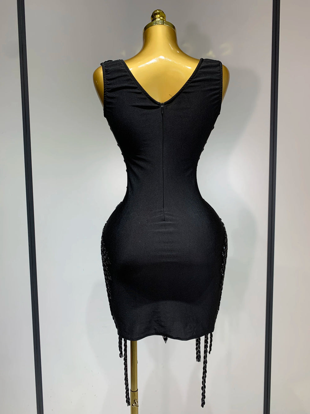 Black dress on a mannequin against a plain background