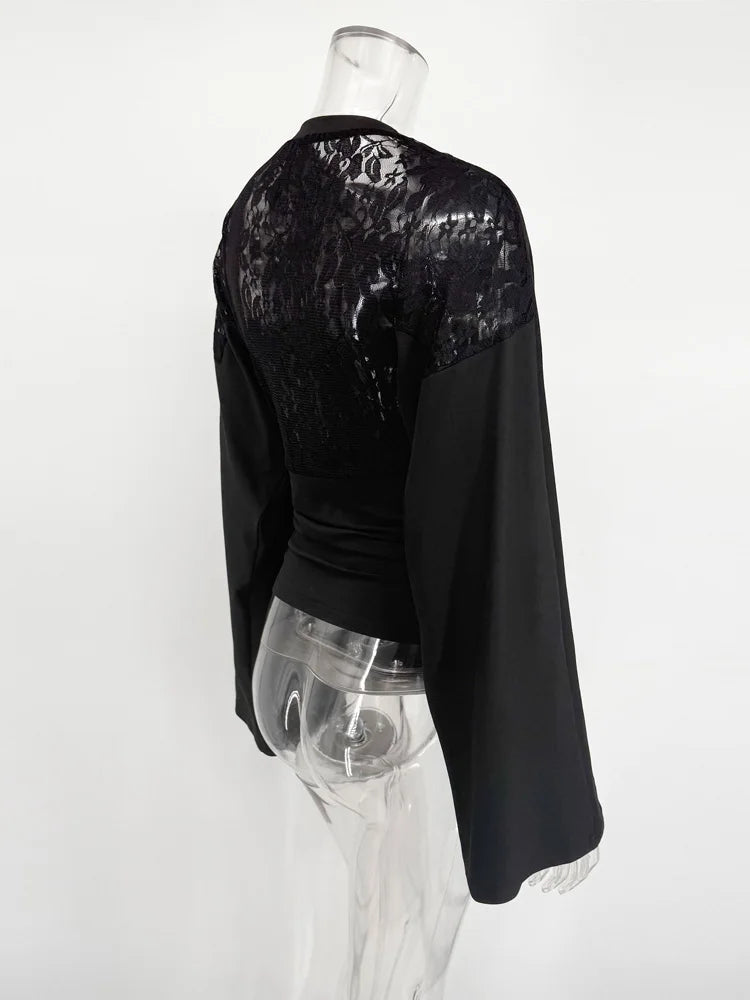 Black long-sleeve top with sequin detailing on a mannequin against a white background