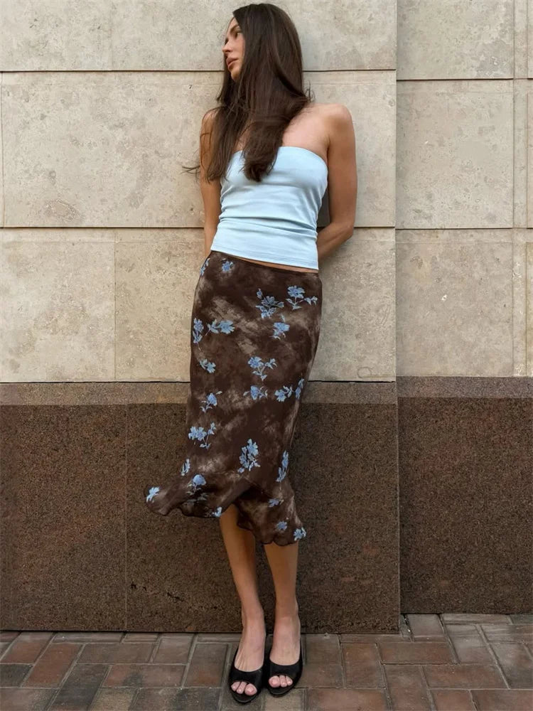 Model wearing a brown tie dye print midi skirt against a textured wall