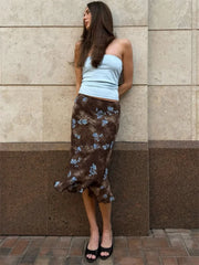 Model wearing a brown tie dye print midi skirt against a textured wall