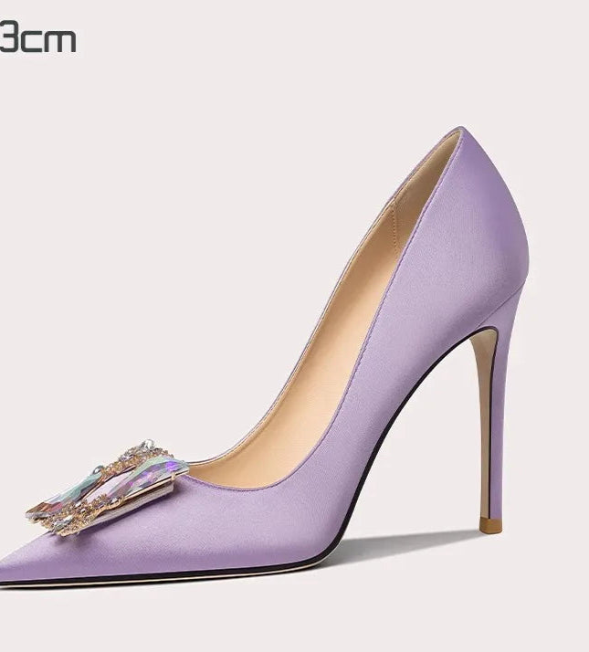 Purple high-heeled shoe with decorative bow on a light gray background