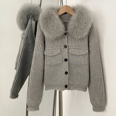 Grey ribbed knit jacket with a large natural grey fur collar.