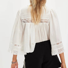 White blouse with lace details worn by a person on a white background