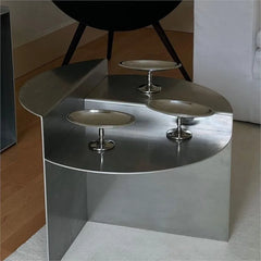 Close-up of the coffee table's smooth surface and sleek stainless steel stand. Golden Atelier 3