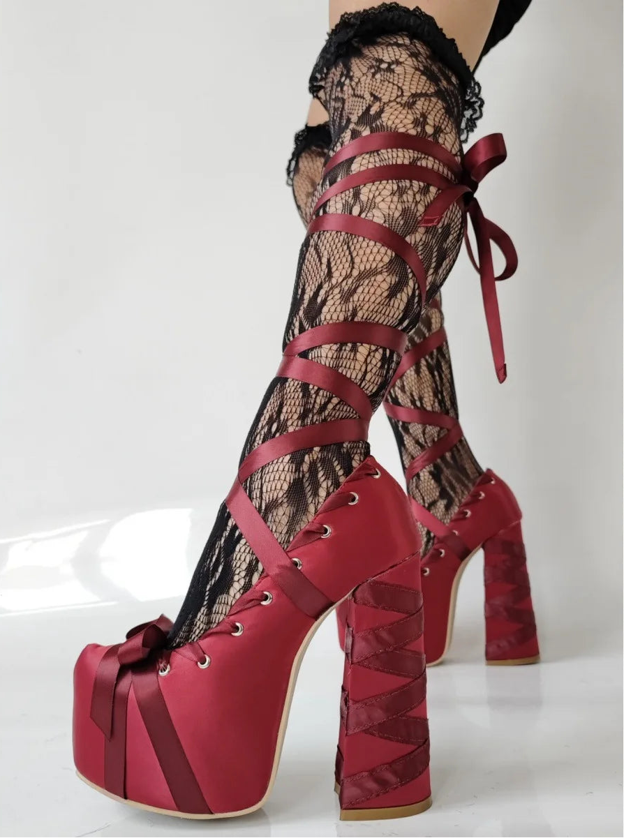 Red platform high heels with lace-up design on a white background