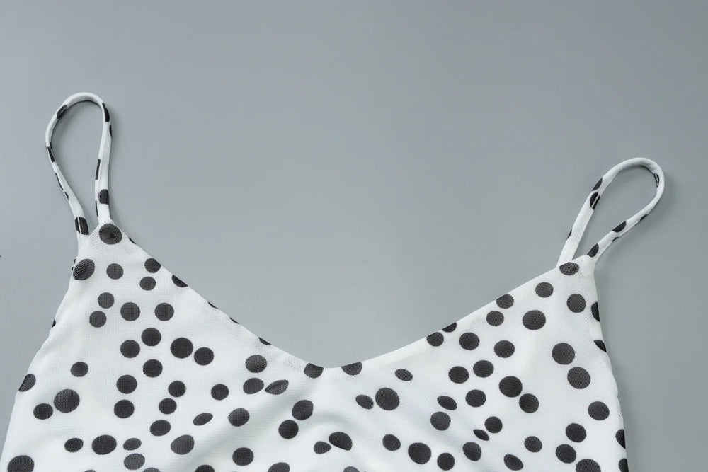 White top with black polka dots on a gray background