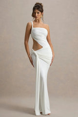 Woman wearing a white one-shoulder dress with cut-out design on a beige background