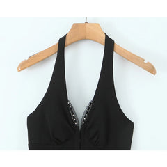 Black halter top with beaded details on a wooden hanger against a white background