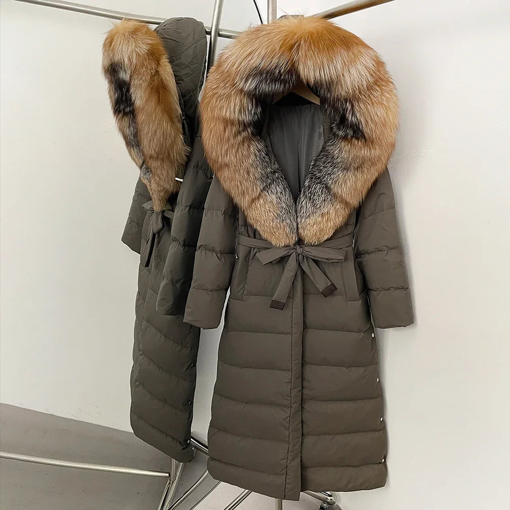 Two puffer coats with fur hoods on a rack against a white wall.