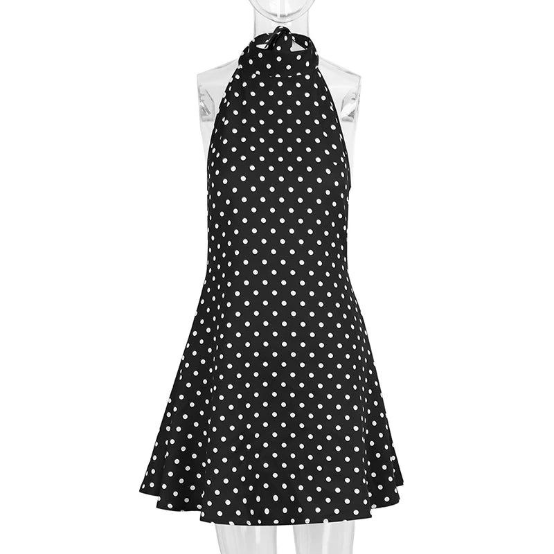 Black dress with white polka dots on a mannequin against a white background