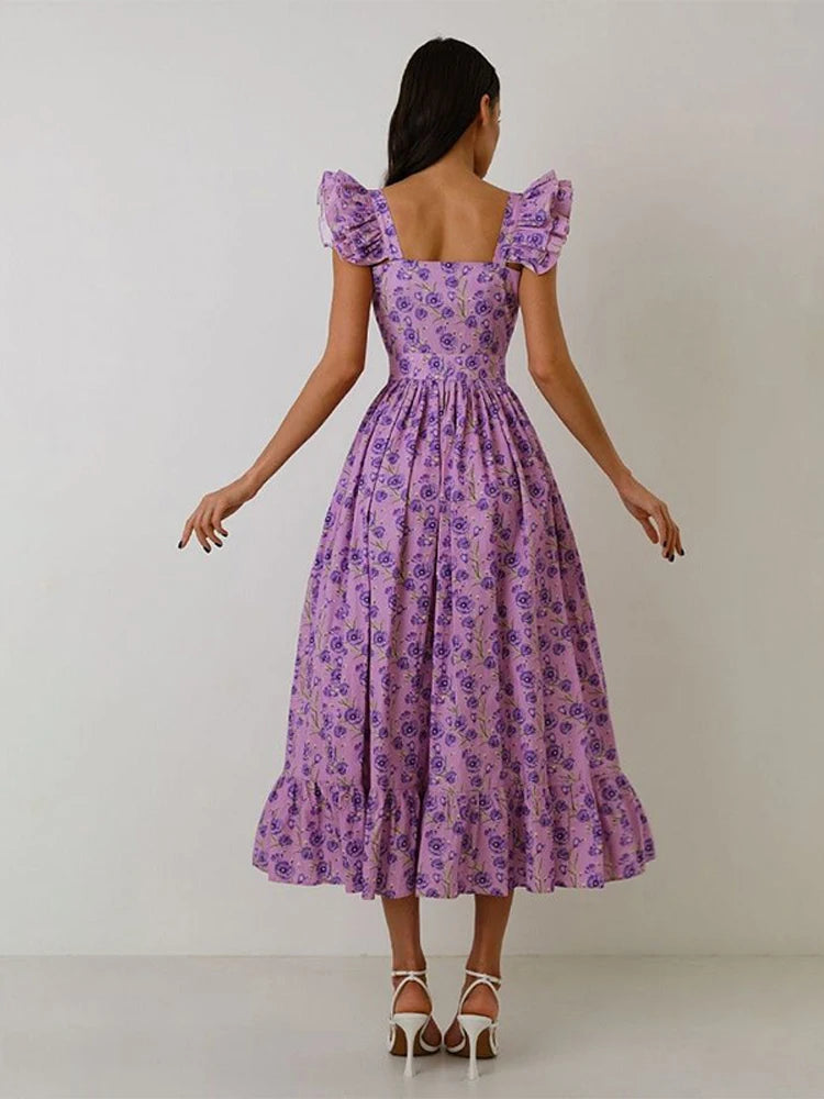Woman wearing a purple floral dress against a white background