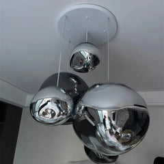 Modern ceiling light fixture with reflective glass spheres on a white ceiling.