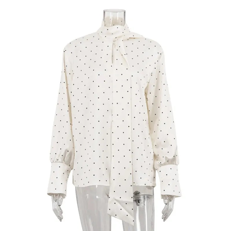 White blouse with black polka dots on a mannequin against a white background