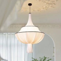 A soft, warm glow emanates from a vintage-style French fabric pendant light hanging in a minimalist living room. B