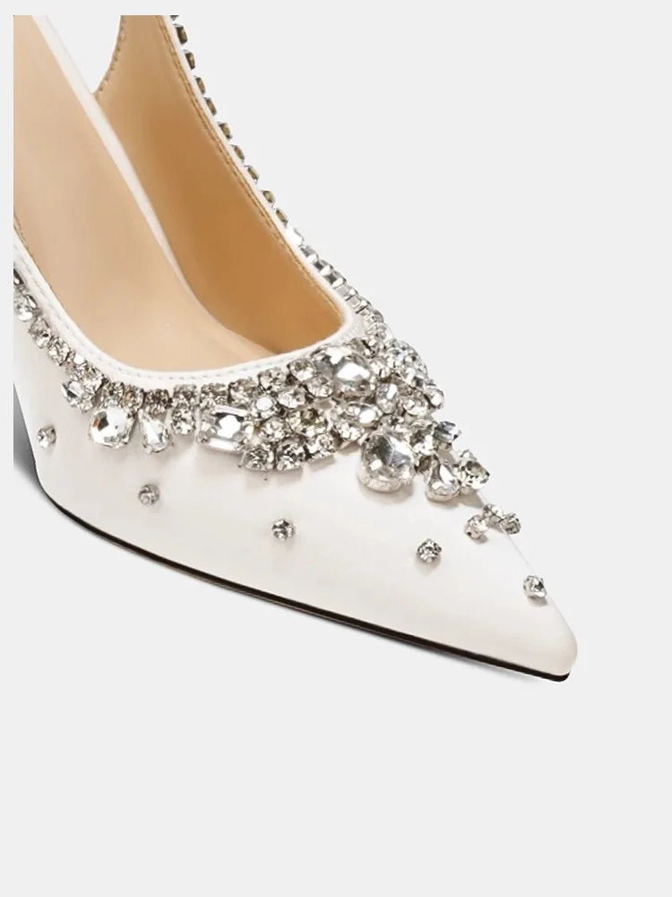 White high-heeled shoe with crystal embellishments on a white background