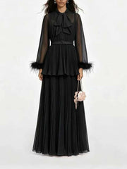 Black pleated maxi dress with bow neck and feather trim