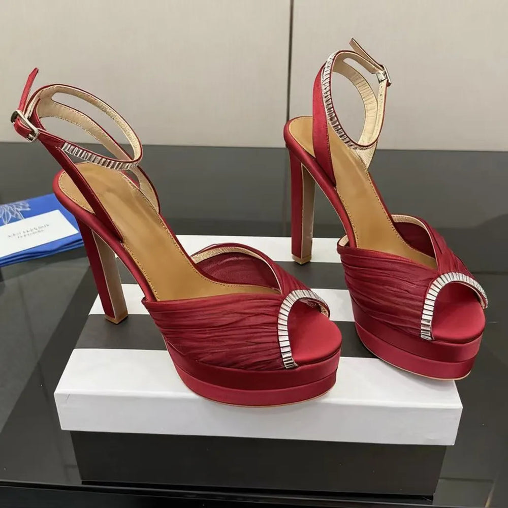 Red platform rhinestone ankle strap heels, pleated satin upper, open toe.