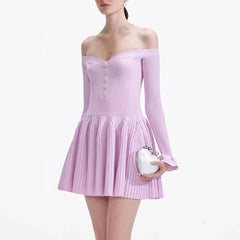 Woman wearing a light purple off-shoulder dress holding a small white handbag on a white background
