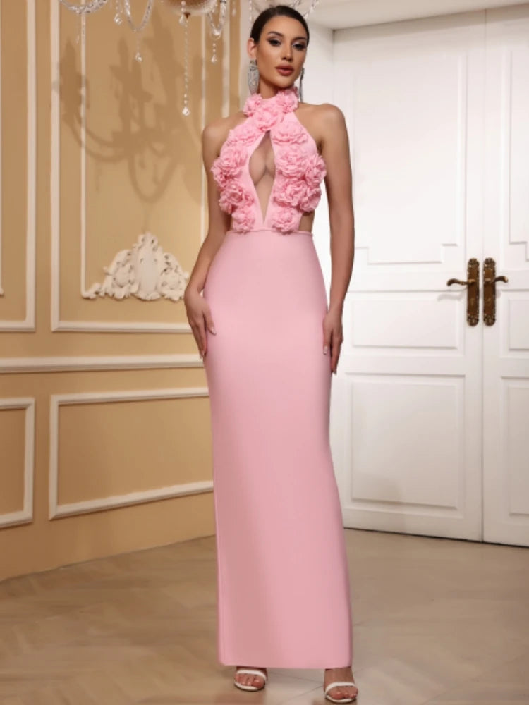 Woman wearing a pink dress with floral details in an elegant indoor setting.