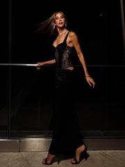 Woman in a black dress standing against a dark background