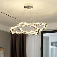 Modern chandelier hanging in a room with neutral decor