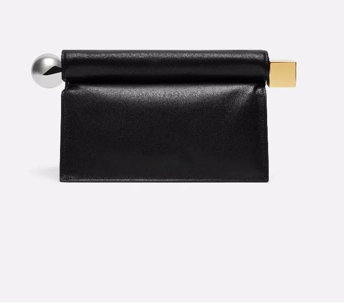 Black leather clutch with gold and silver accents on a light gray background