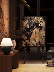 Decorative interior scene with a lamp, books, and a decorative wall piece.