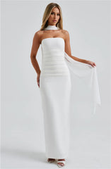 A woman wearing a white strapless gown on a plain background