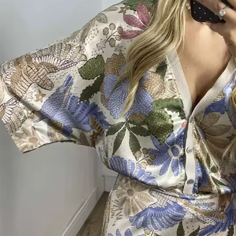 Person wearing a floral patterned kimono-style garment with a plain background