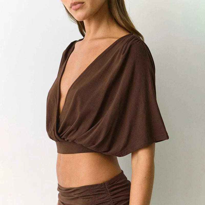 Brown cropped top worn by a person on a plain background