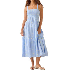 A woman wearing a light blue dress with white floral patterns 