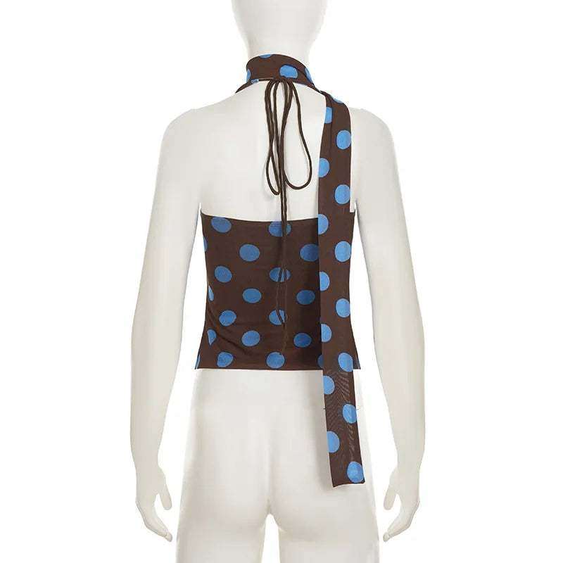 Mannequin wearing a brown halter top with blue polka dots on a white background