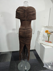 Brown pleated dress on a mannequin against a white wall.