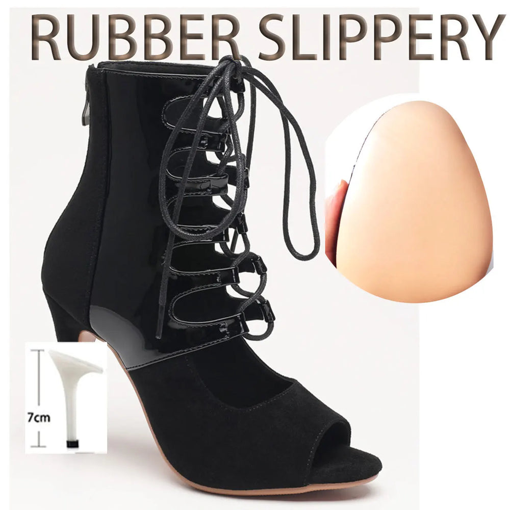 Black high-heeled shoe with lace-up design next to a measuring stick and an egg for scale on a white background.