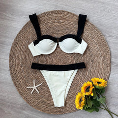 Flat lay of a contrast trim bikini set with decorative elements.