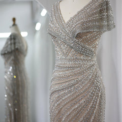 Close-up of the delicate cap sleeves and shimmering silver fabric of the mermaid gown. Golden Atelier 3