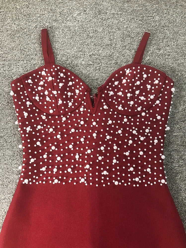 Red dress with white bead embellishments on a gray background