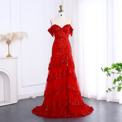Red evening gown on a mannequin against a white curtain background