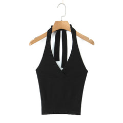 Black halter top on a wooden hanger against a white background