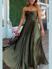 Woman wearing a strapless green dress on a wooden deck.