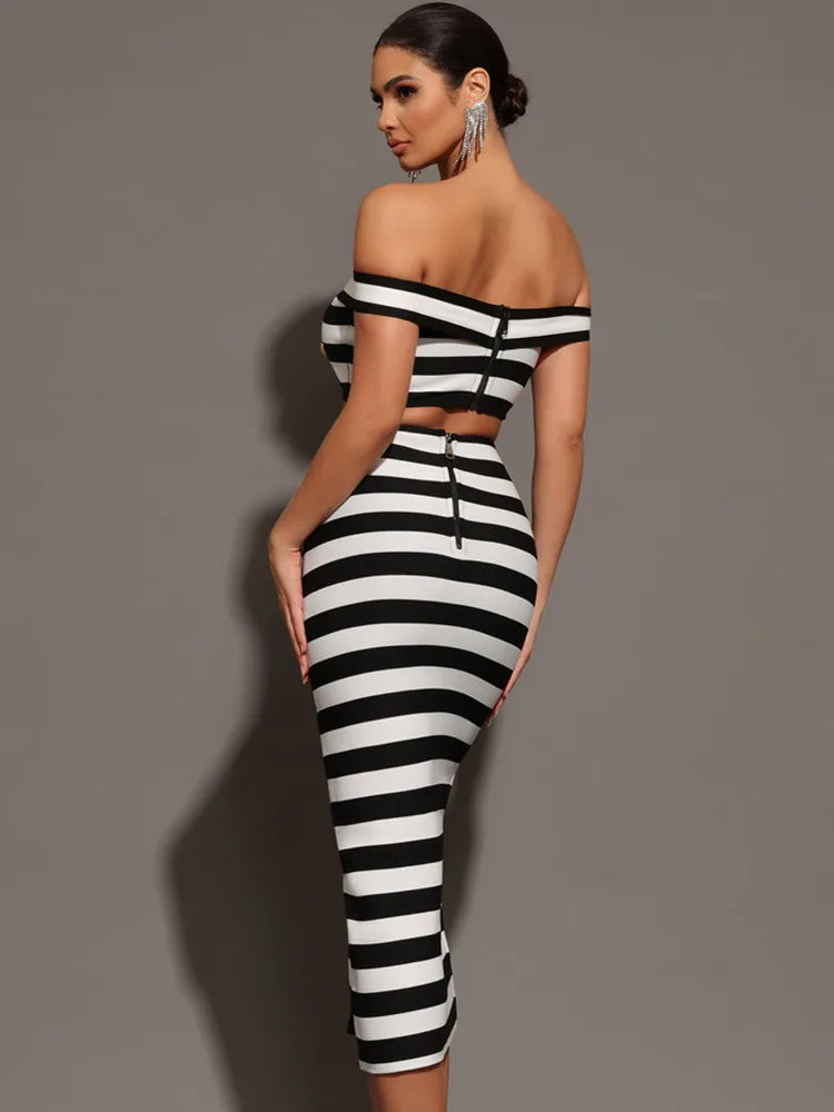 Woman wearing a black and white striped dress against a gray background