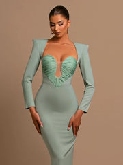 Woman wearing a green dress with a matching jacket against a beige background