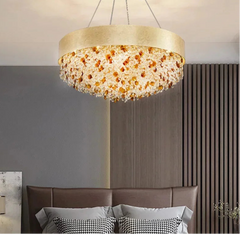 Chandelier hanging in a room with a gray wall and brown headboard.