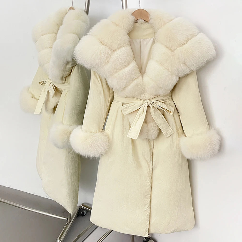 Cream-colored coat with fur trim on a rack against a white background